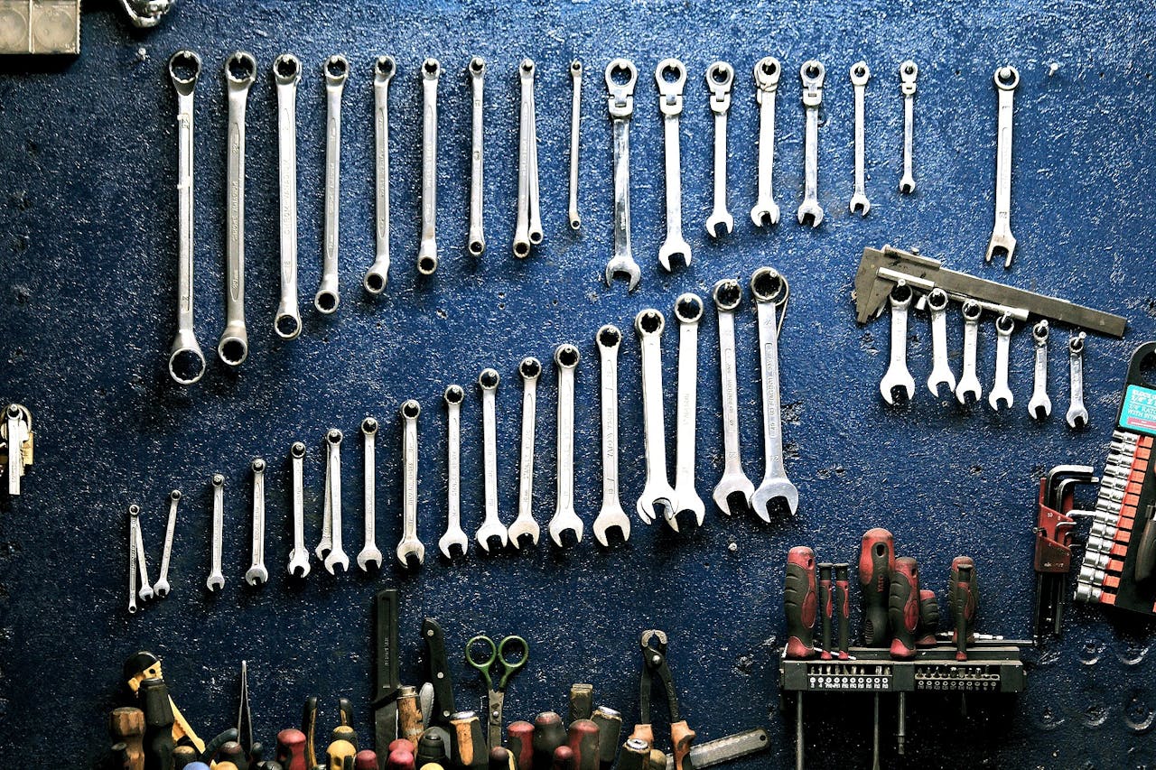 heros-img Neatly arranged wrenches and tools on a workshop wall, ideal for mechanics.